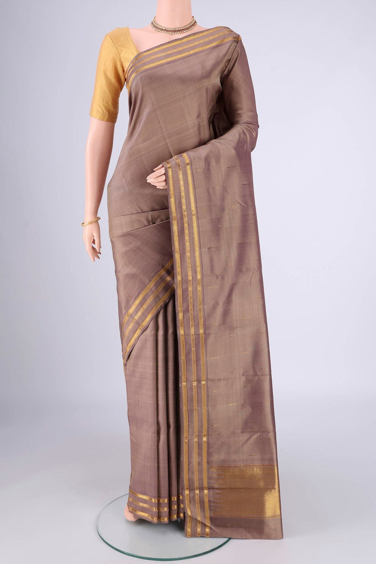 Brown Kanchipuram Silk Saree with Plain Body and Zari Border.  displayed on a mannequin