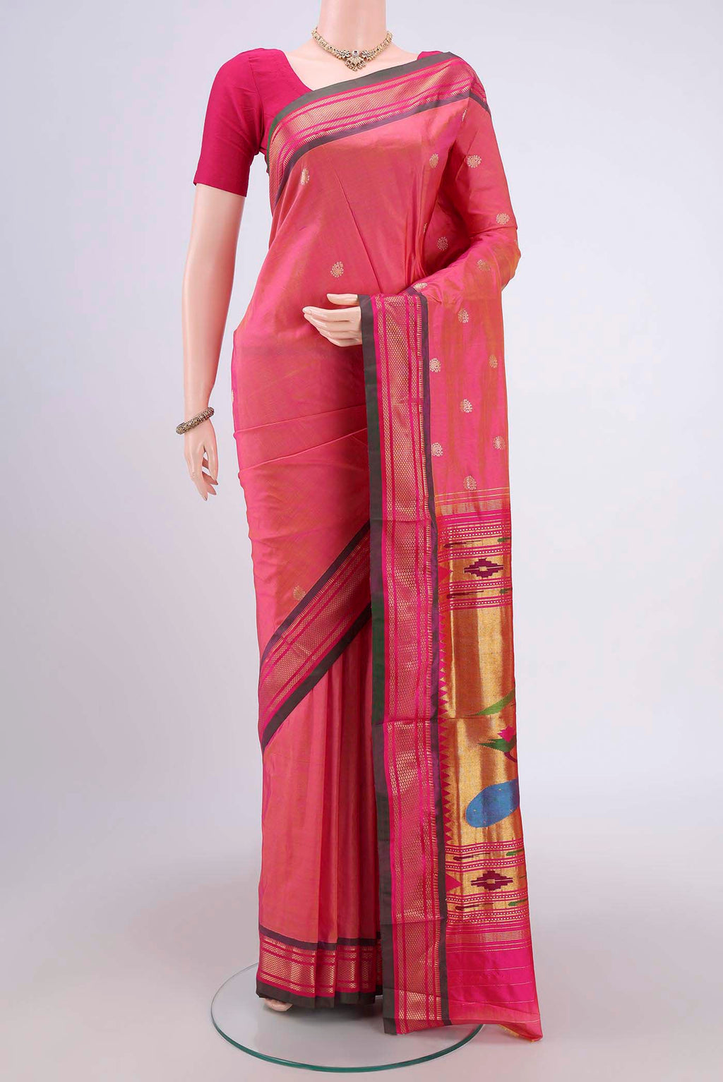 Pinkish Yellow Soft Silk Saree with Zari Butta on the body and Zari Border.  displayed on a mannequin