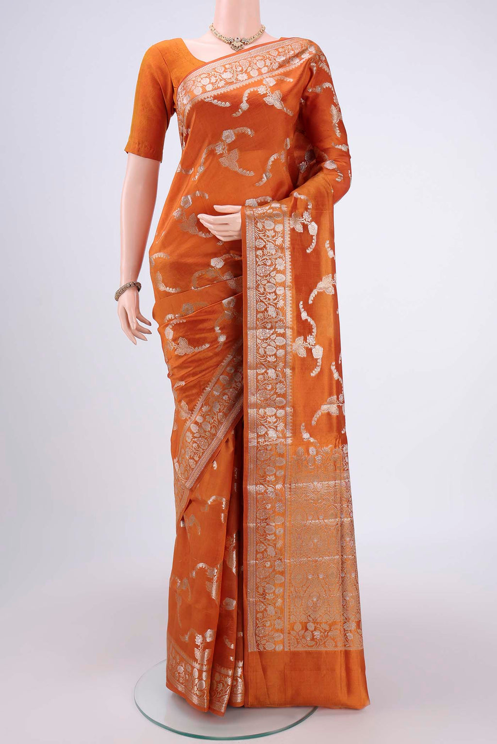 Rust Banarasi Raw Silk Saree with Zari Butta on the body and Zari Border.  displayed on a mannequin