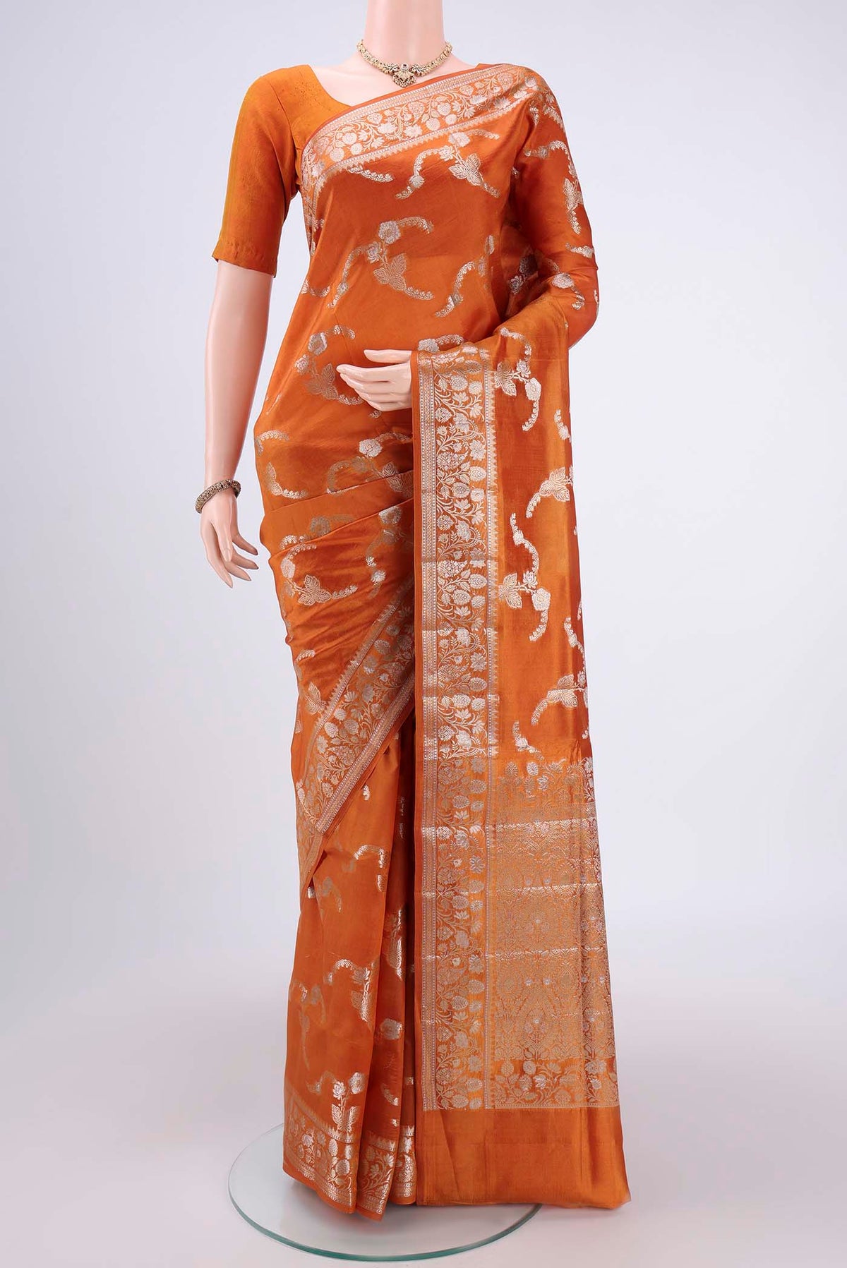 Rust Banarasi Raw Silk Saree with Zari Butta on the body and Zari Border.  displayed on a mannequin