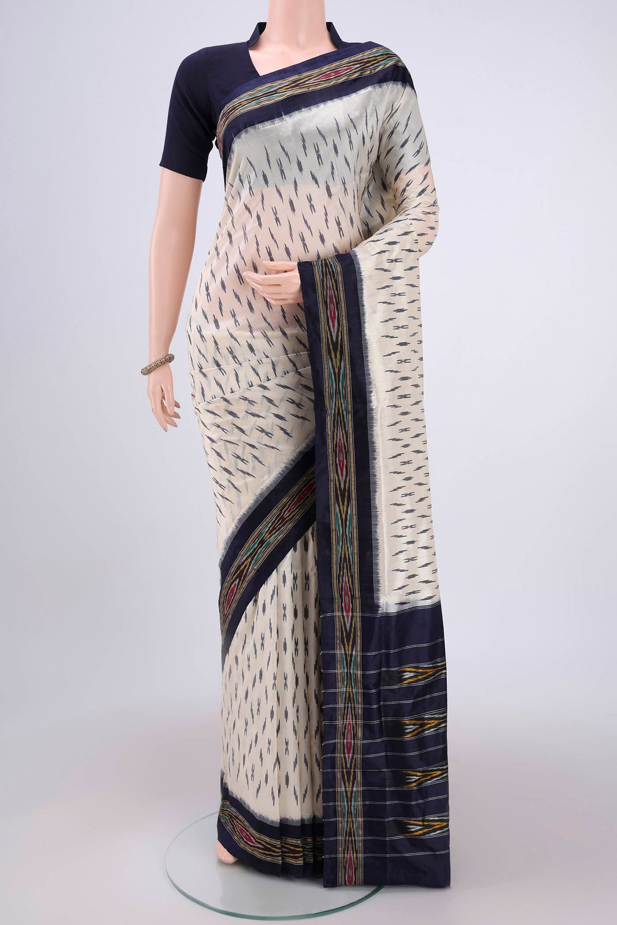 Off White Pochampally Silk Saree with Ikat design on the body and Ikat Border.  displayed on a mannequin