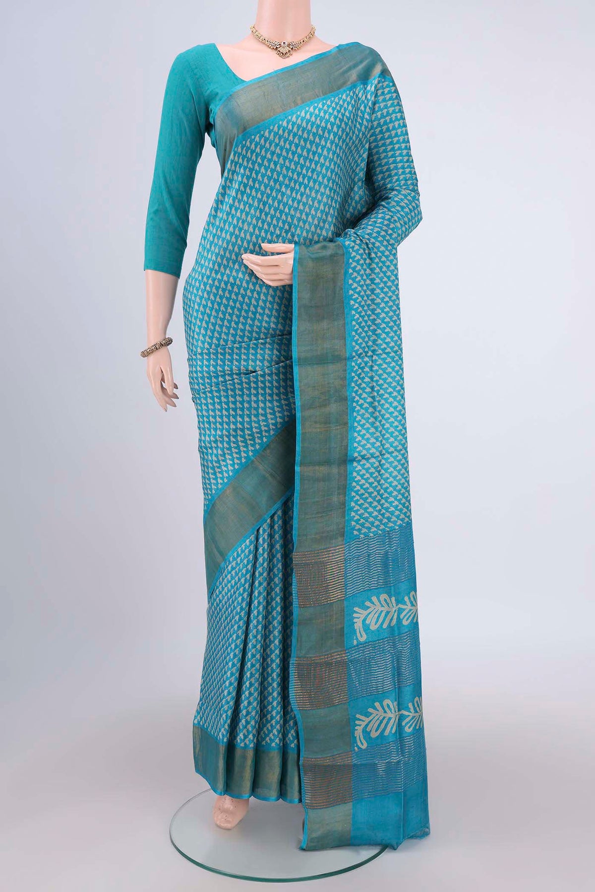 Turquoise Tussar Silk Saree with Printed design on the body and Zari Border.  displayed on a mannequin