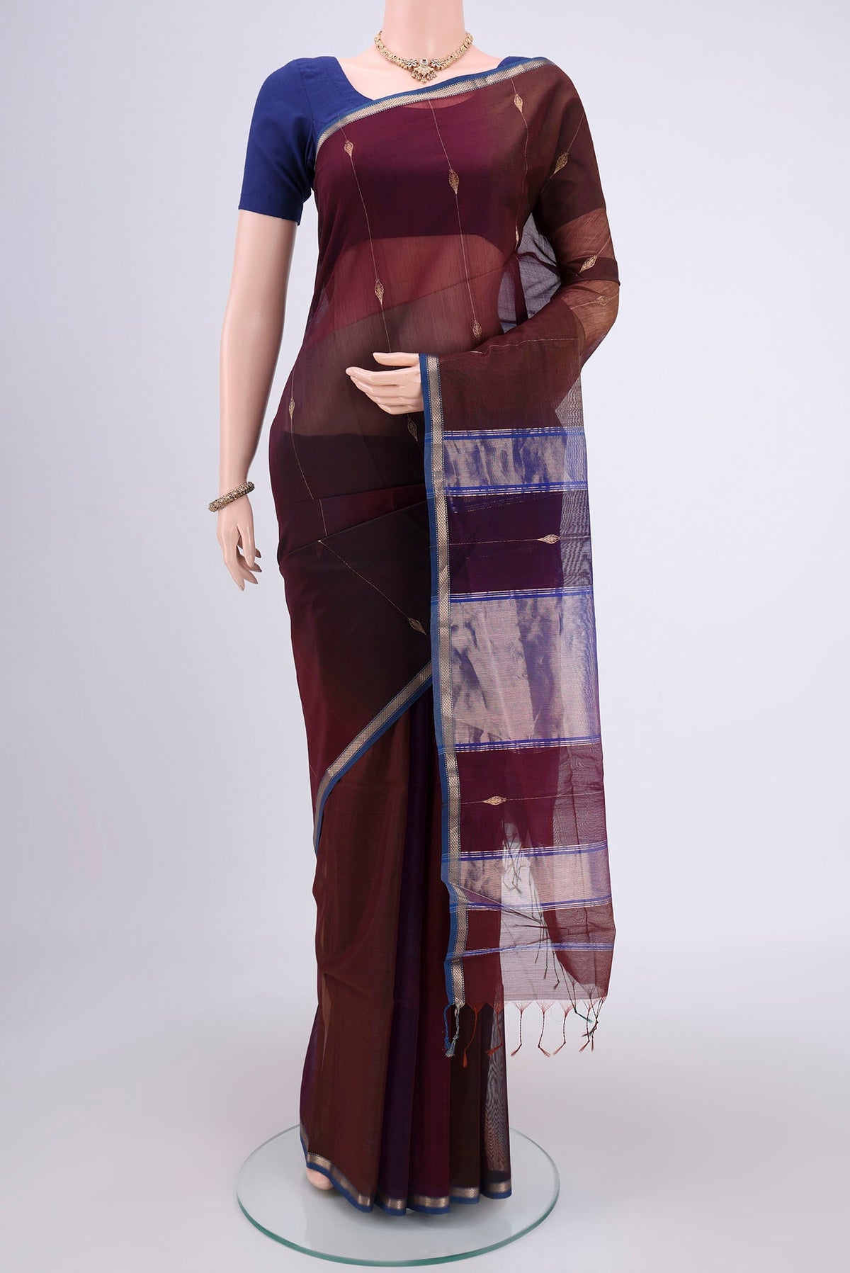 Brown Maheshwari Silk Cotton Saree with Zari And Thread Butta on the body and Zari Border.  displayed on a mannequin