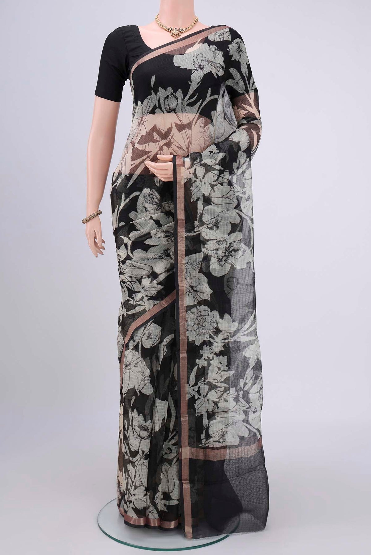 Black Kota Silk Saree with Printed design on the body and Zari Border.  displayed on a mannequin