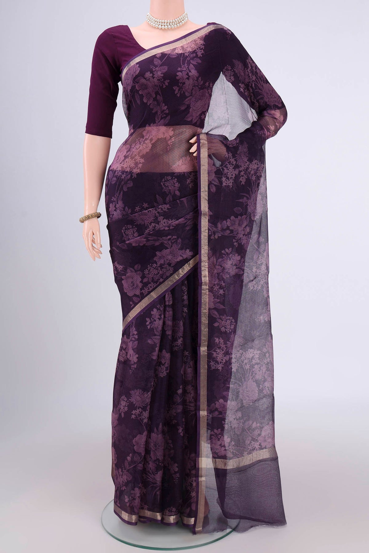 Purple Kota Silk Saree with Floral Print on the body and Zari Border.  displayed on a mannequin