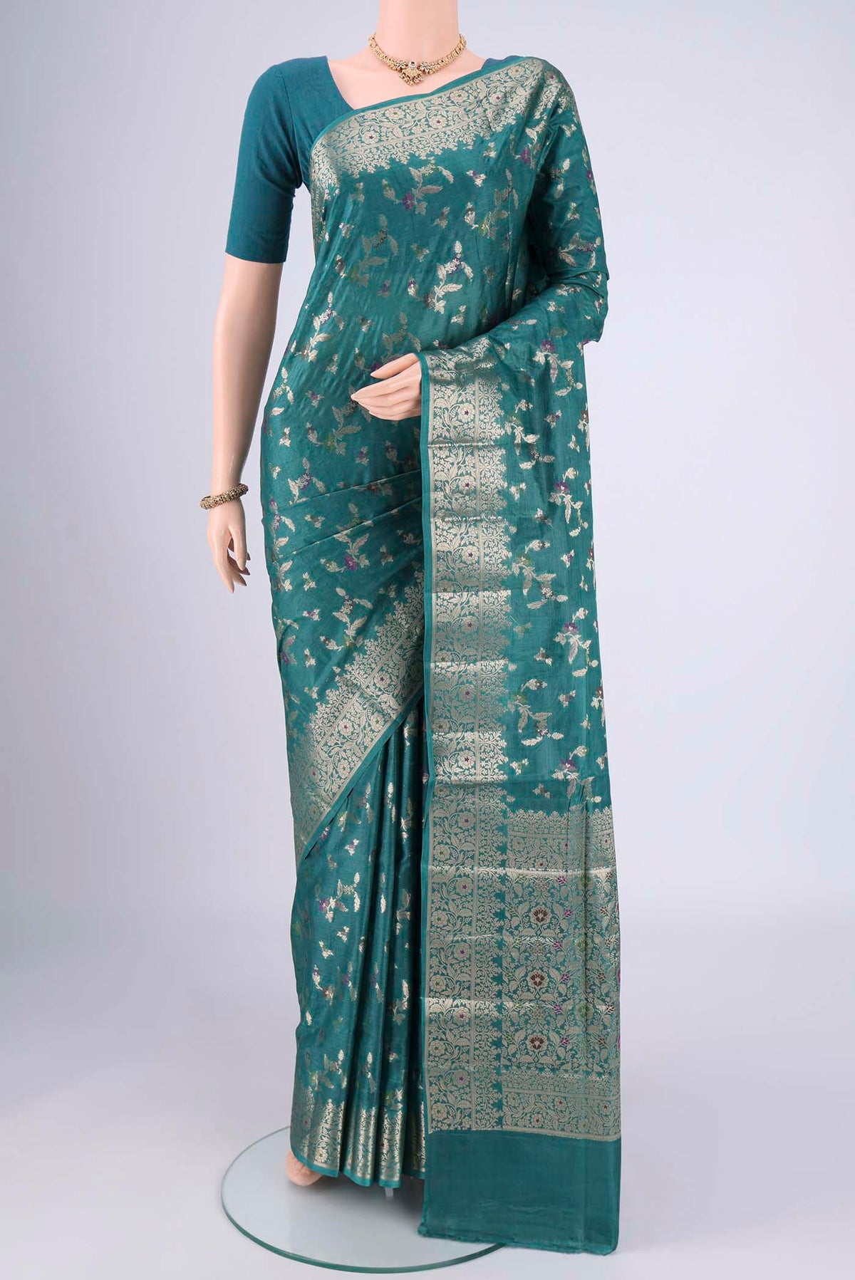 Sea Green Banarasi Tussar Silk Saree with Zari And Thread Butta on the body and Zari And Thread Border.  displayed on a mannequin