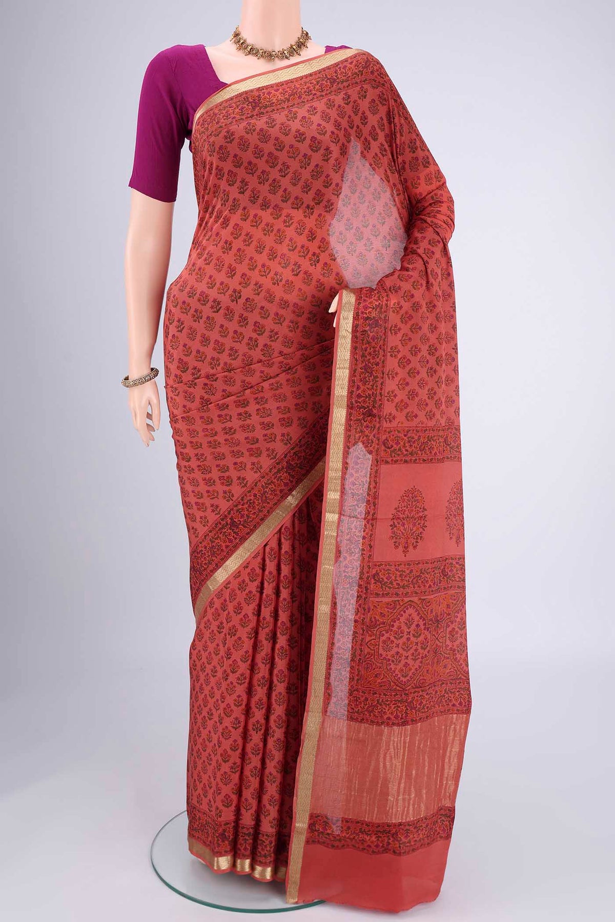 Coral Mysore Crepe Saree with Floral Print on the body and Zari Border.  displayed on a mannequin