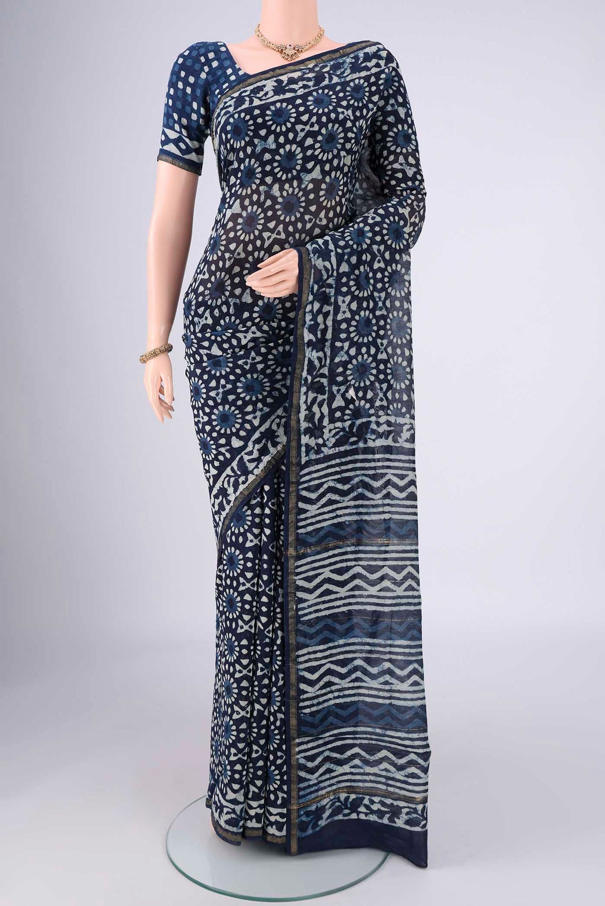 Indigo Maheshwari Silk Cotton Saree with Batik Print on the body and Zari Border.  displayed on a mannequin