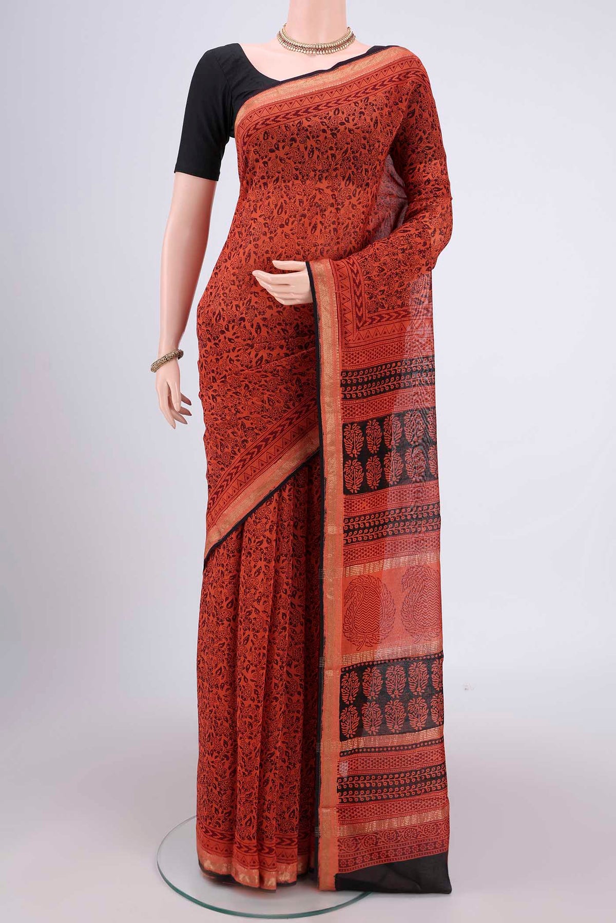 Orange Maheshwari Silk Cotton Saree with Printed design on the body and Zari Border.  displayed on a mannequin