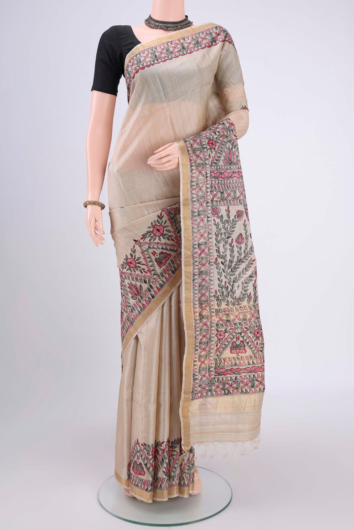 Beige Tussar Silk Saree with Printed design on the body and Zari Border.  displayed on a mannequin