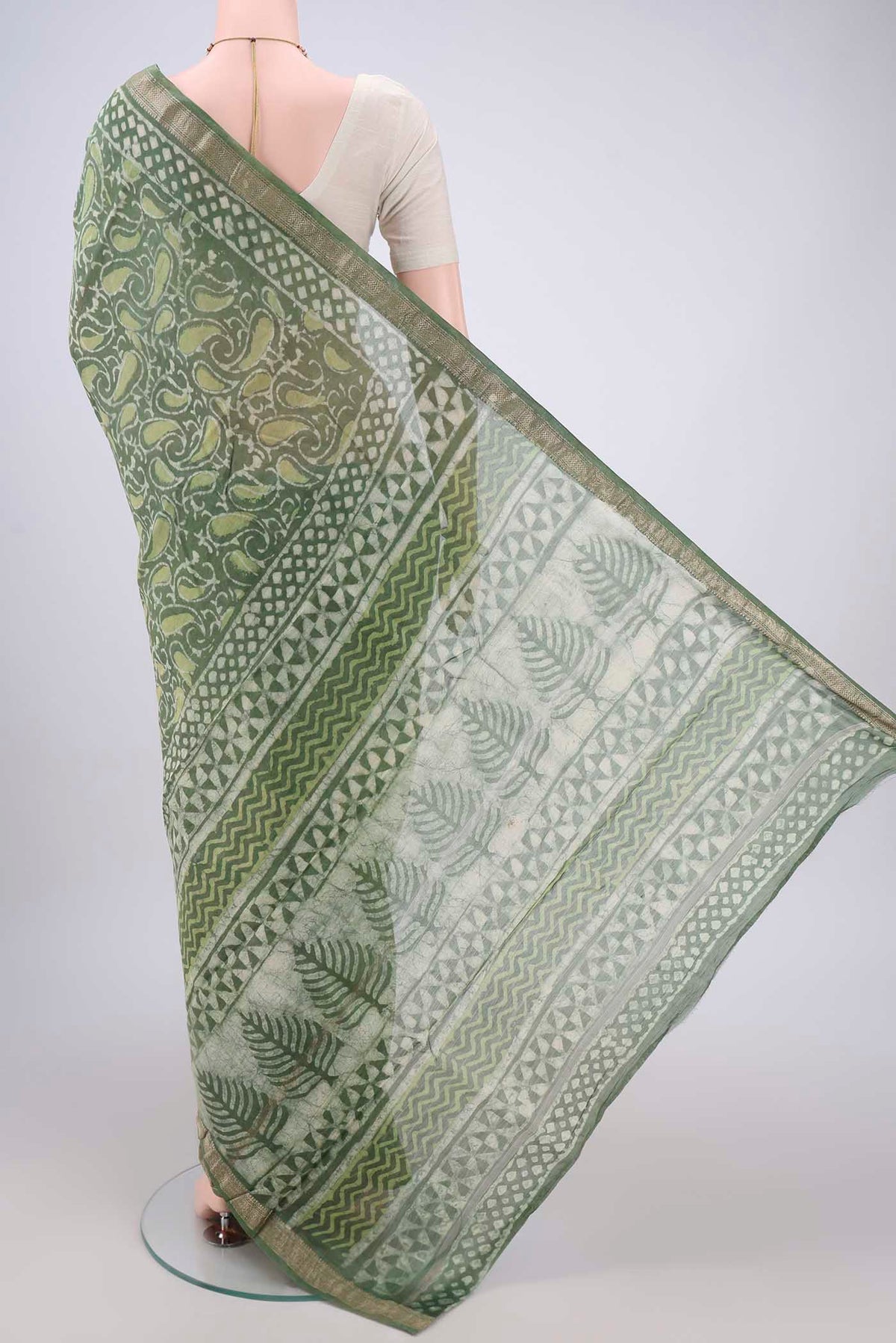 Flat view of Olive Green Maheshwari Silk Cotton Saree with Batik Print on the body and Zari Border. 
