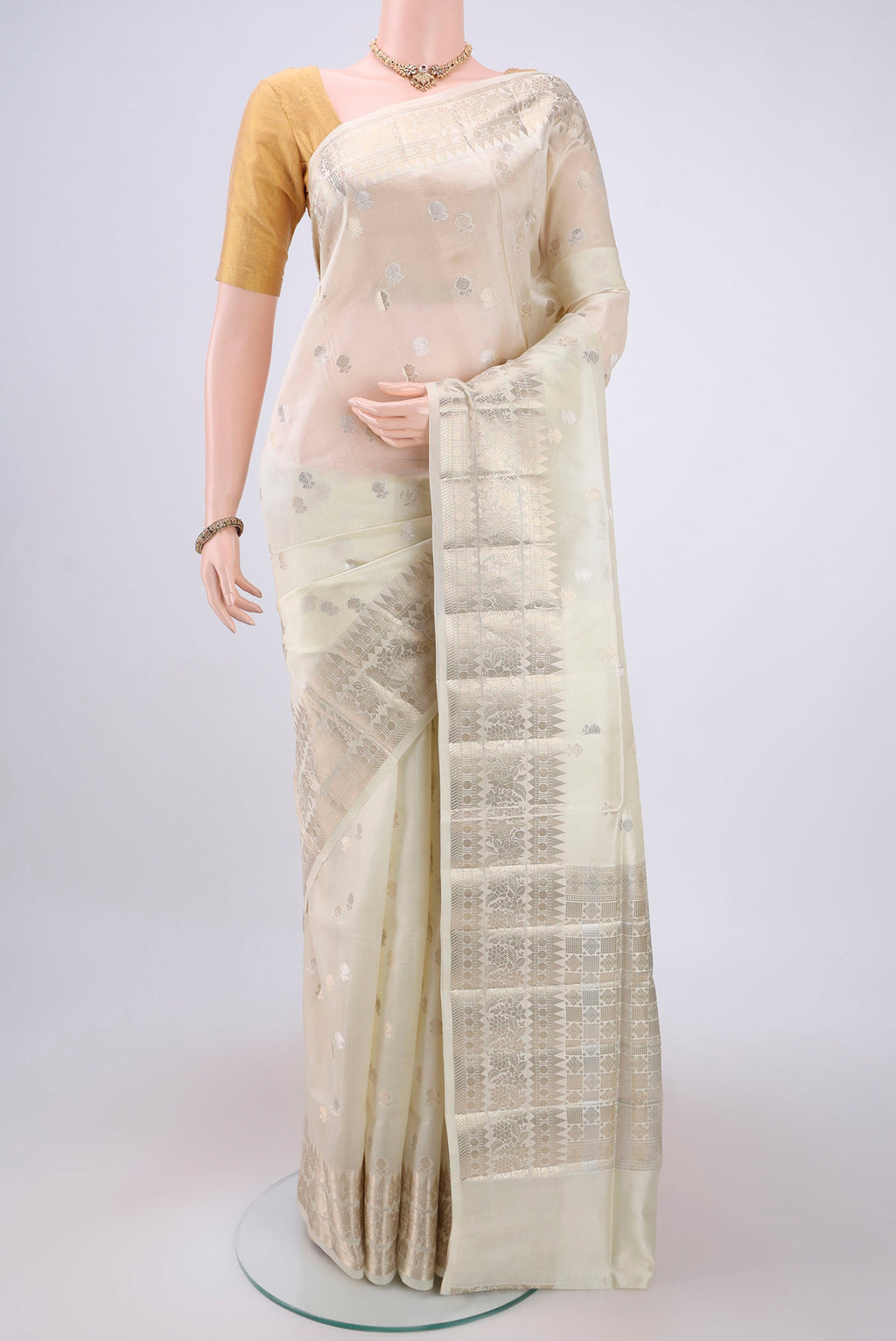 Cream Banarasi Raw Silk Saree with Zari Butta on the body and Zari Border.  displayed on a mannequin