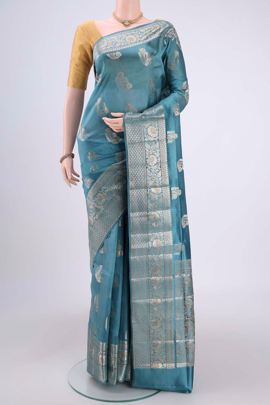 Sky Blue Banarasi Raw Silk Saree with Zari Butta on the body and Zari Border.  displayed on a mannequin
