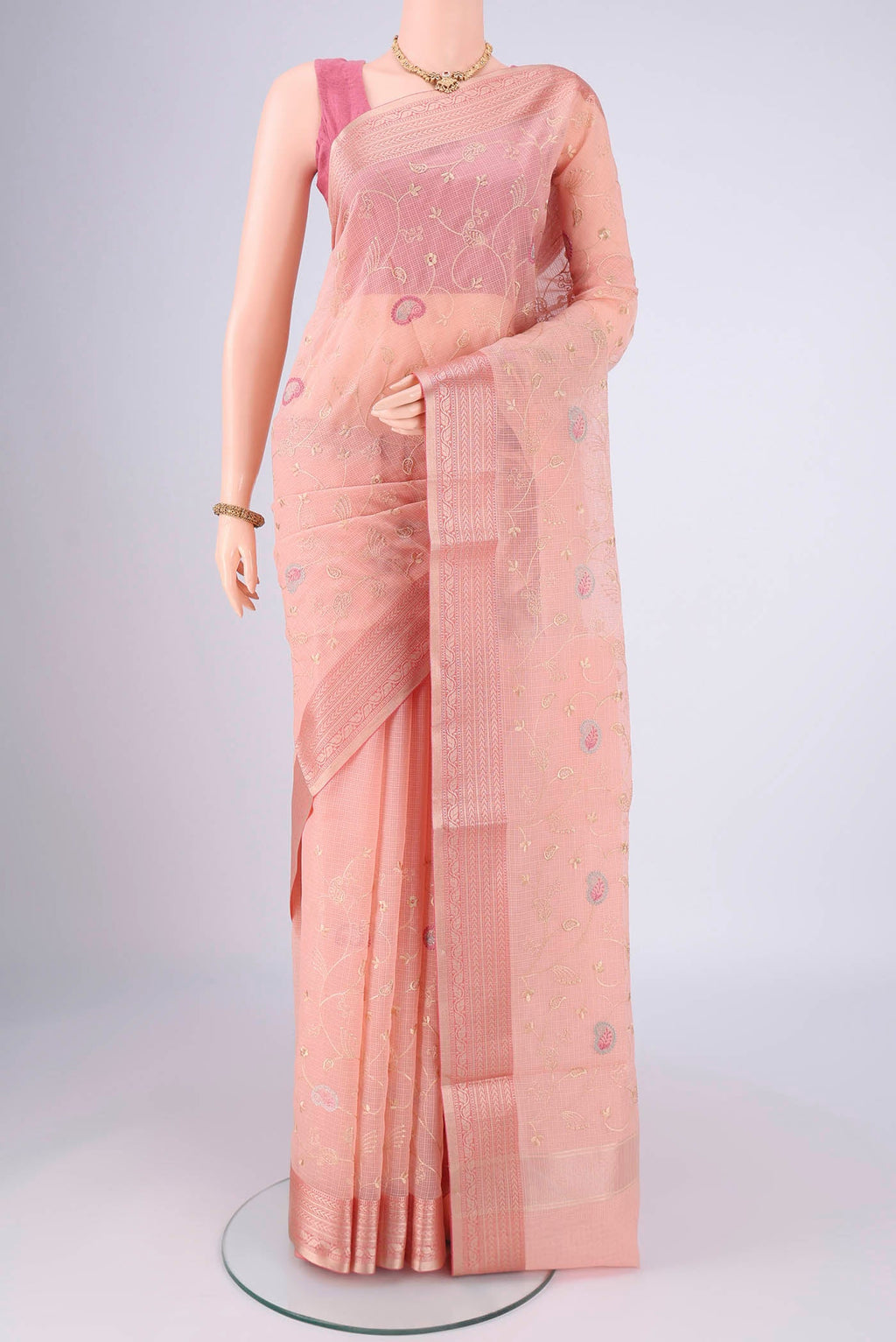 Peach Blended Kota Cotton Saree with Embroidery on the body and Zari Border.  displayed on a mannequin
