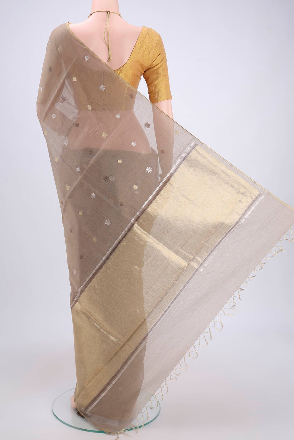 Flat view of Beige MP Tussar Saree with Zari Butta on the body and Zari Border. 