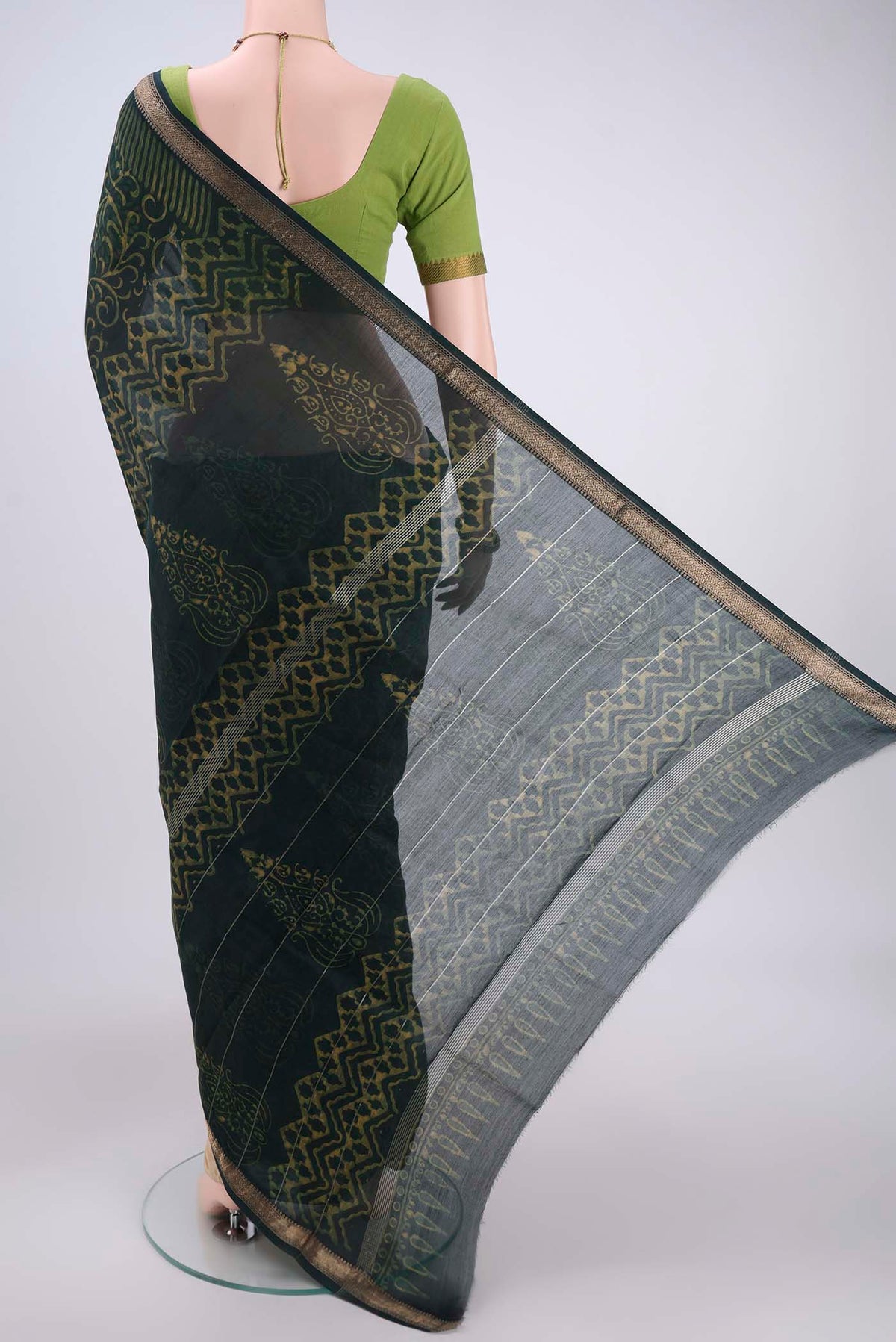 Flat view of Bottle Green Maheshwari Silk Cotton Saree with Batik Print on the body and Zari Border. 