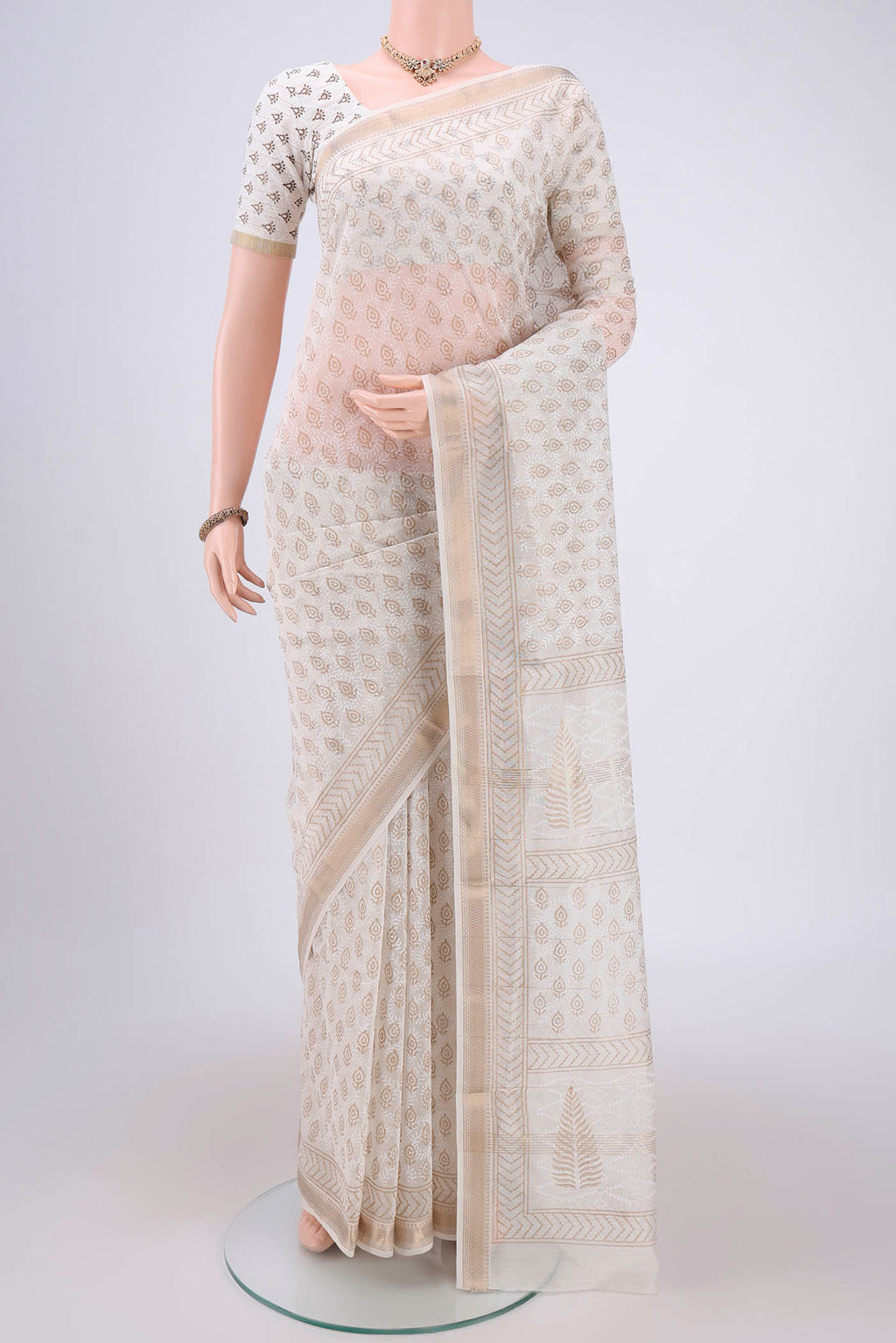 Off White Maheshwari Silk Cotton Saree with Batik Print on the body and Zari Border.  displayed on a mannequin