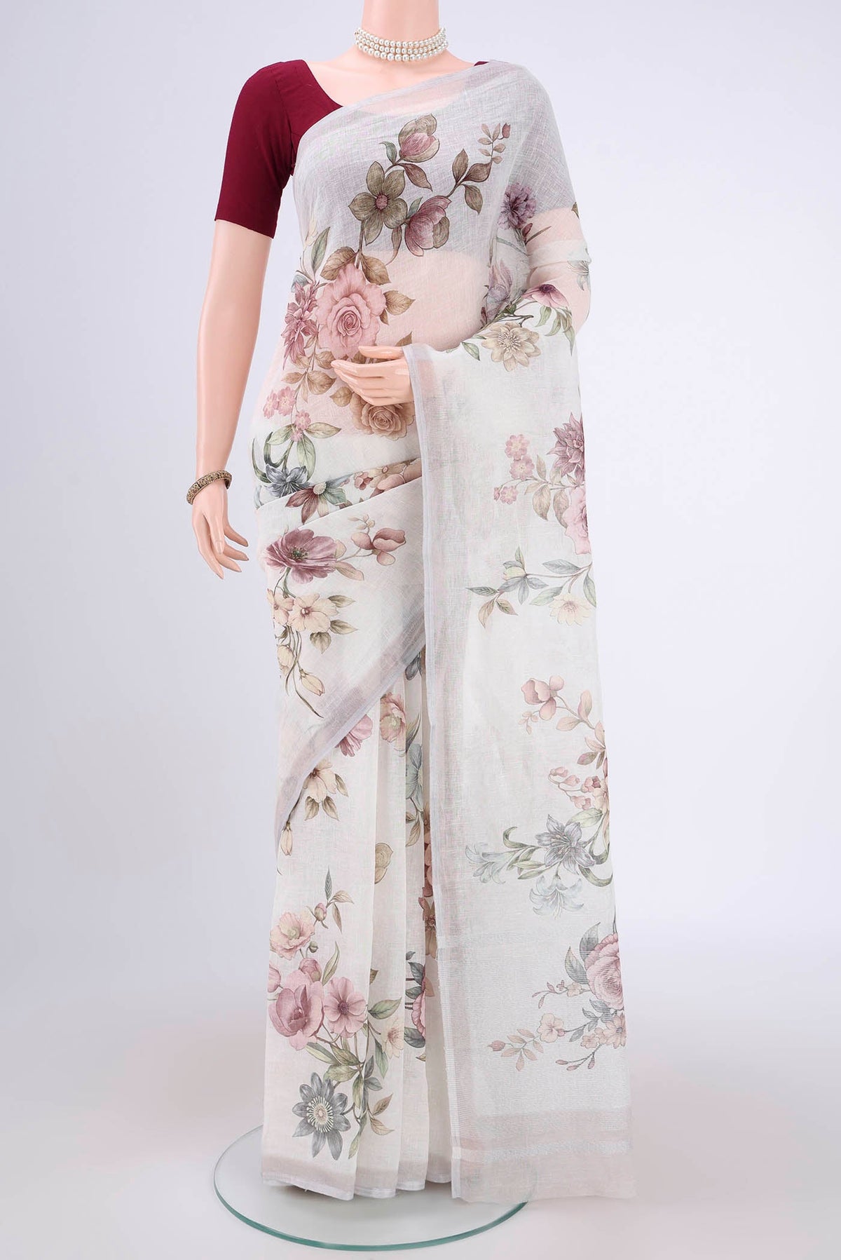 Off White Linen Saree with Floral Print on the body and Zari Border.  displayed on a mannequin