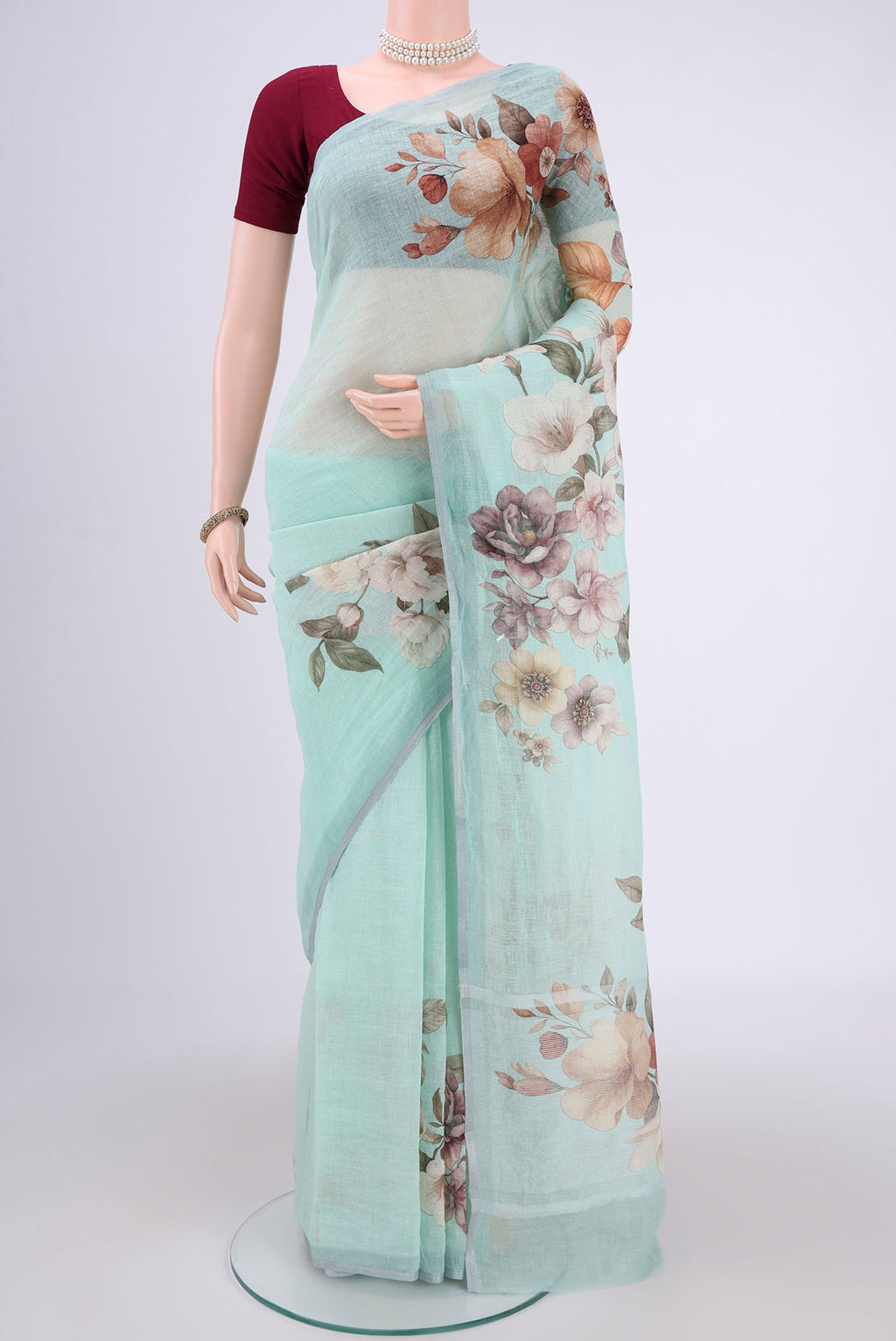 Sea Green Linen Saree with Floral Print on the body and Zari Border.  displayed on a mannequin
