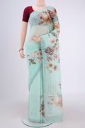 Sea Green Linen Saree with Floral Print on the body and Zari Border.  displayed on a mannequin