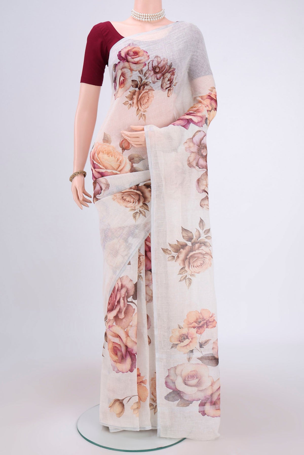 White Linen Saree with Floral Print on the body and Zari Border.  displayed on a mannequin
