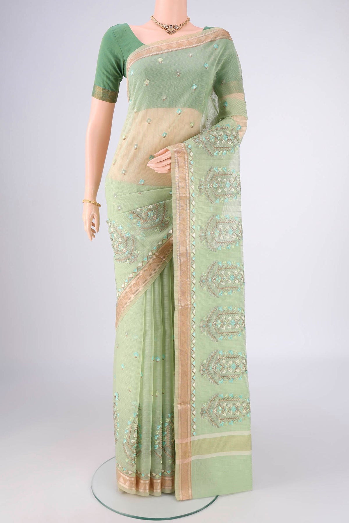 Light Green Blended Kota Cotton Saree with Embroidery on the body and Zari Border.  displayed on a mannequin