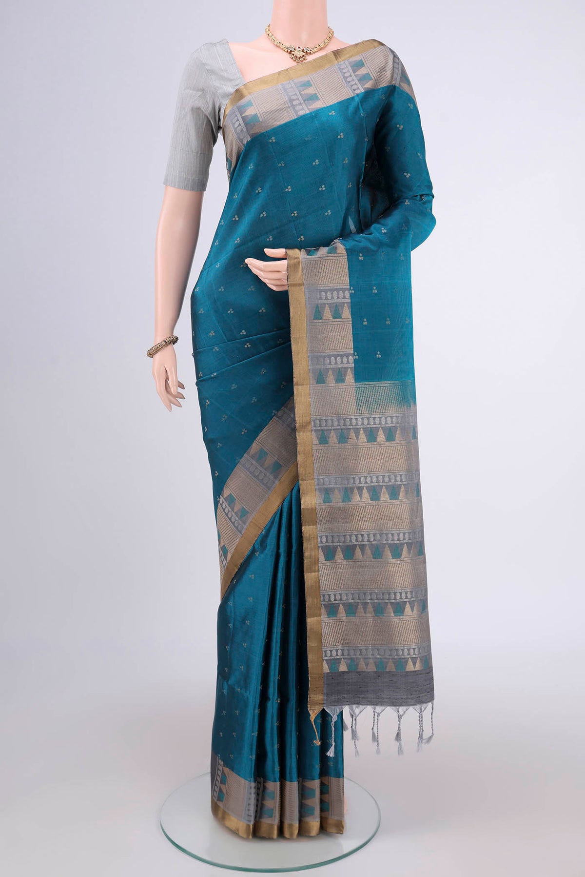 Peacock Blue Soft Silk Saree with Zari Butta on the body and Zari Border.  displayed on a mannequin