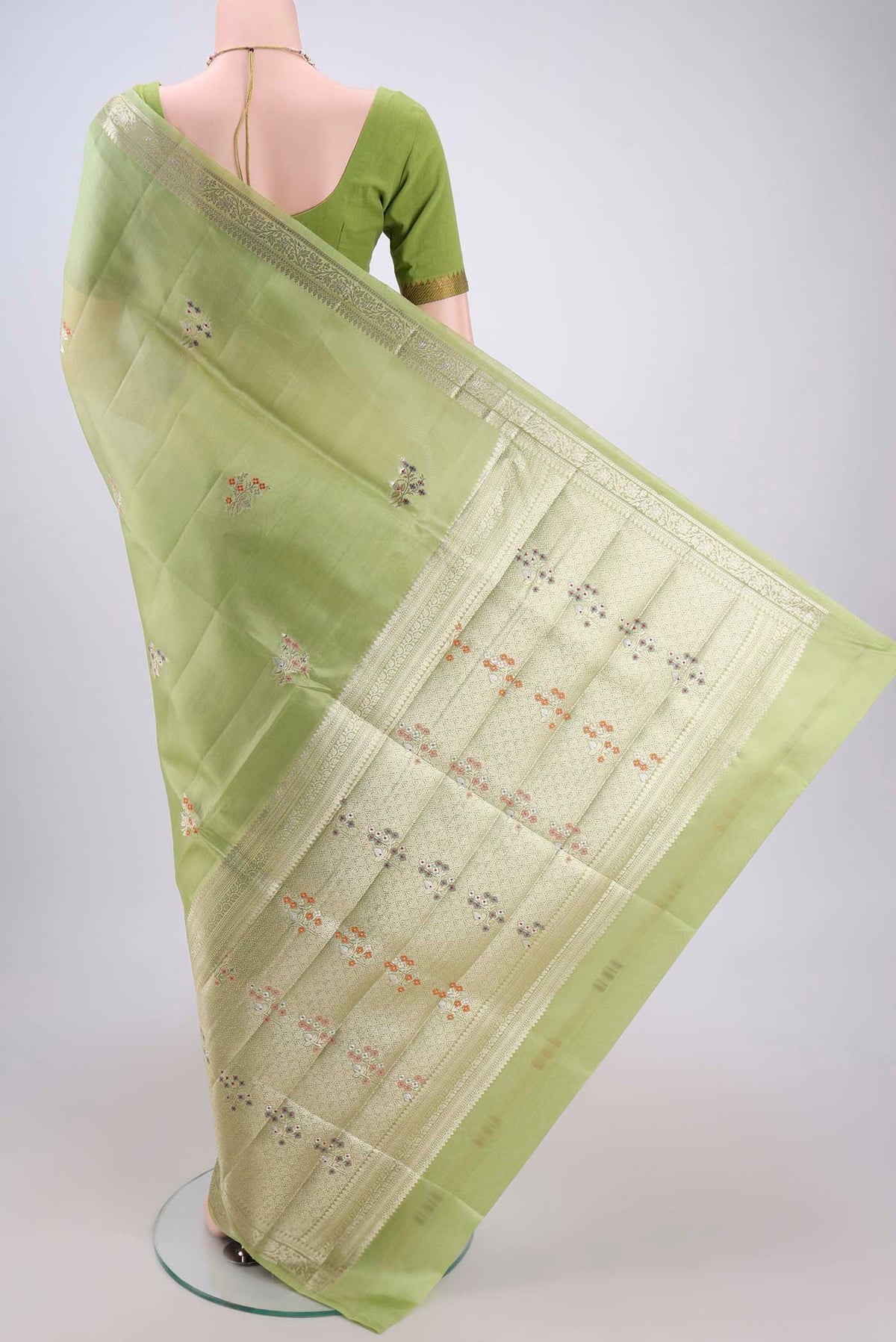 Flat view of Light Green Banarasi Raw Silk Saree with Zari And Thread Butta on the body and Zari Border. 