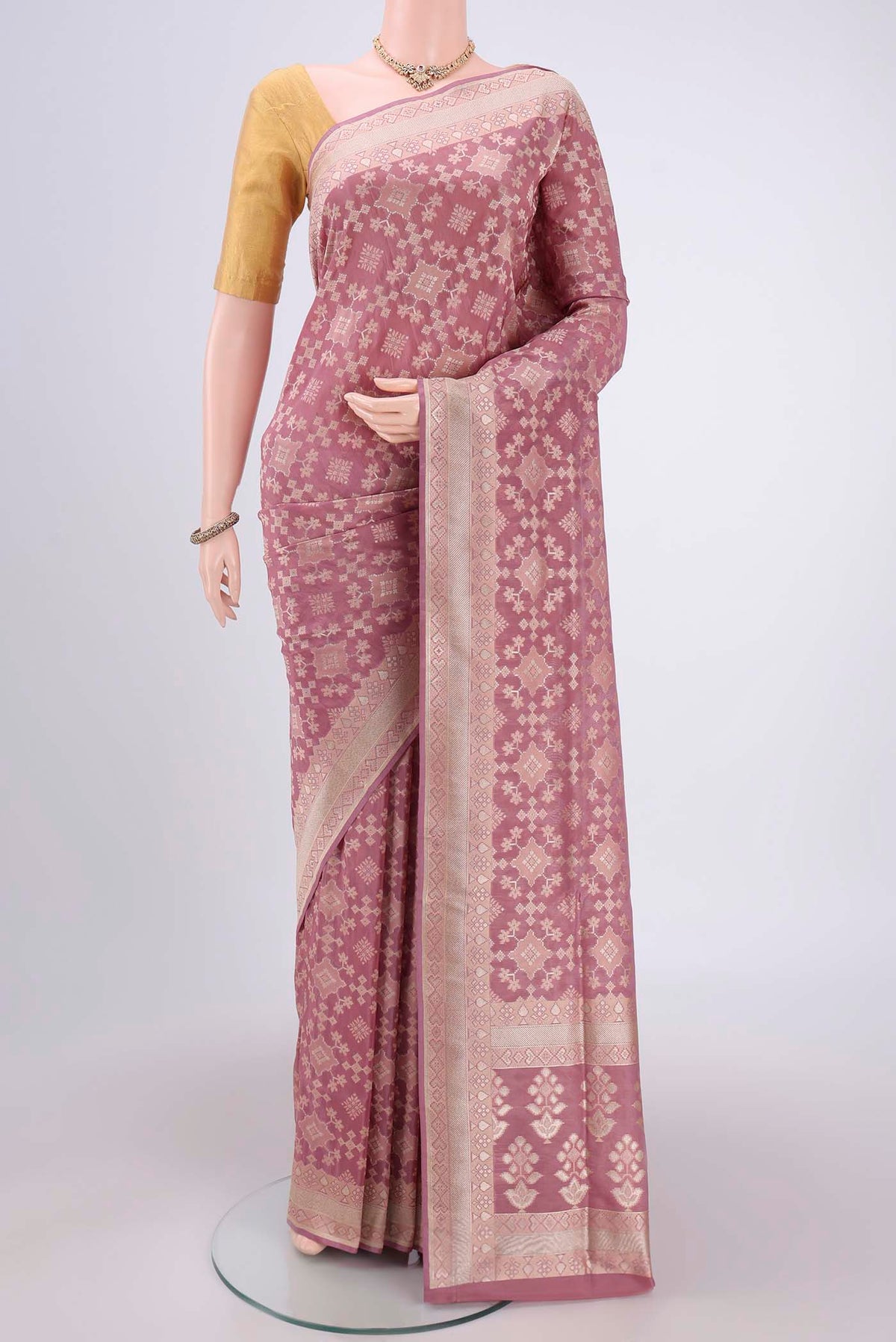 Mauve Banarasi Silk Saree with Zari And Thread Butta on the body and Zari Border.  displayed on a mannequin