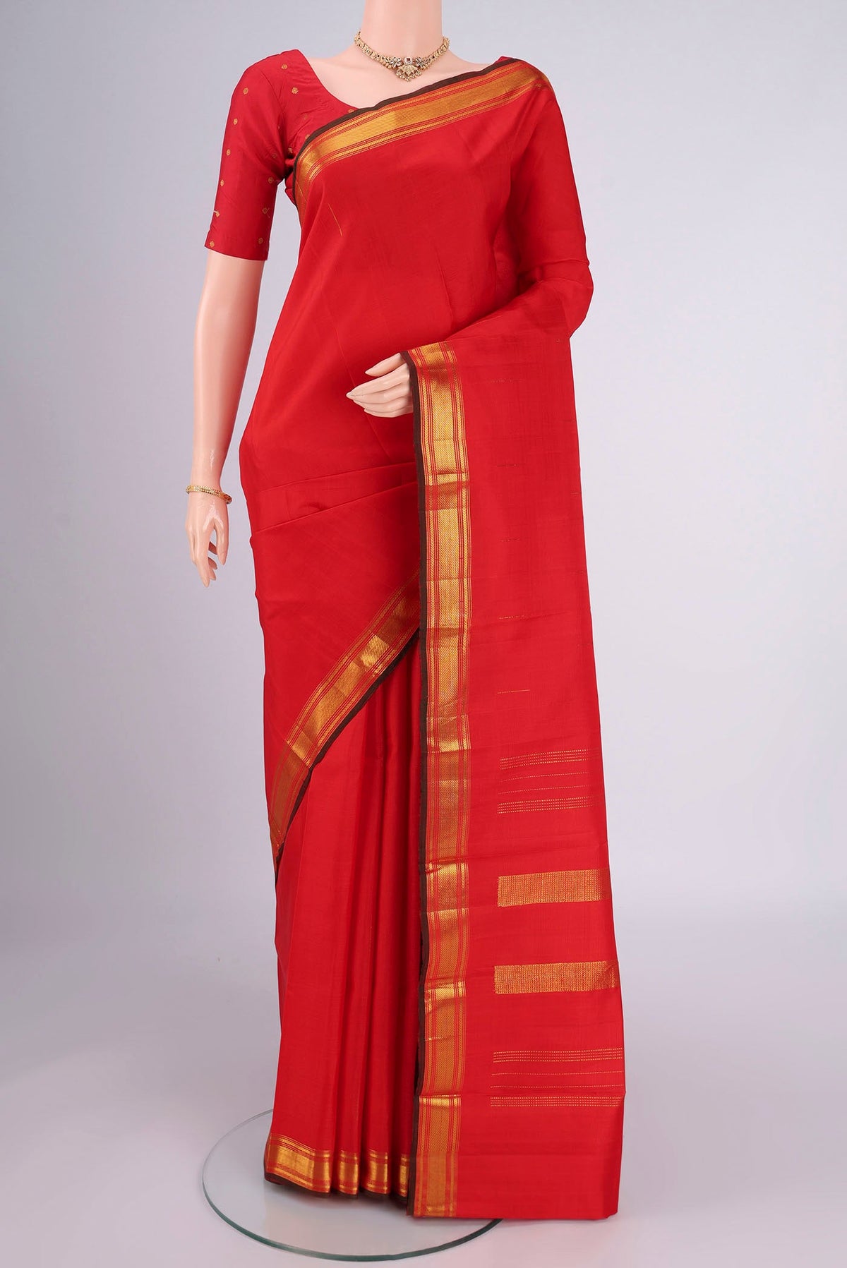 Red Kanchipuram Silk Saree with Zari Butta on the body and Zari Border.  displayed on a mannequin