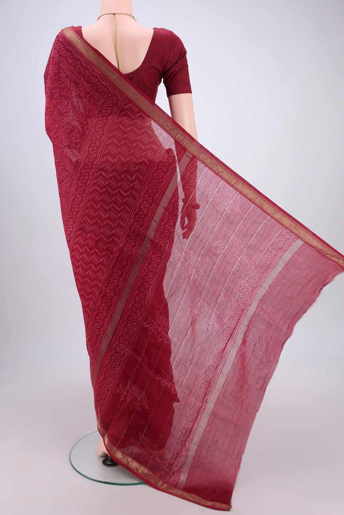 Flat view of Maroon Maheshwari Silk Cotton Saree with Printed design on the body and Zari Border. 