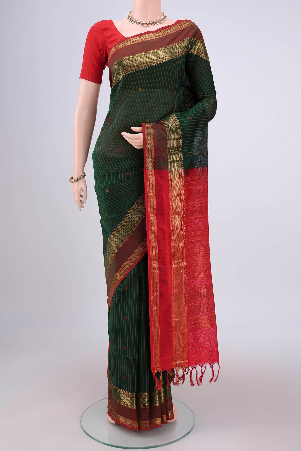 Bottle Green Coimbatore Silk Cotton Saree with Stripes on the body and Zari And Thread Border.  displayed on a mannequin