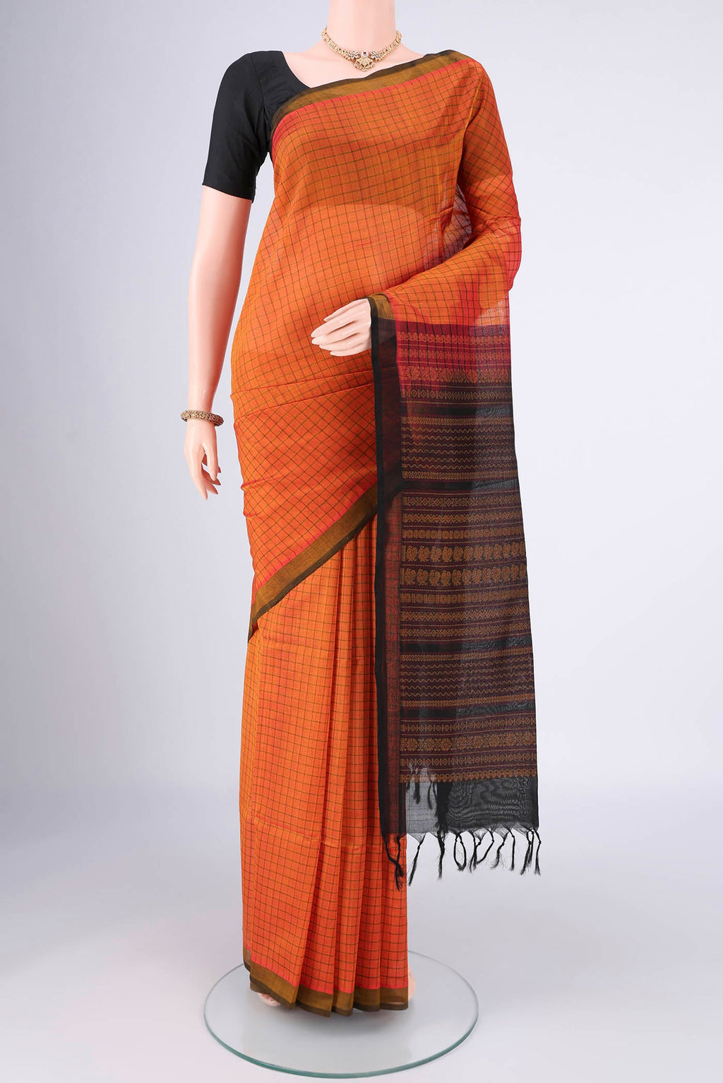 Rust Coimbatore Silk Cotton Saree with Checked design on the body and Plain Border.  displayed on a mannequin
