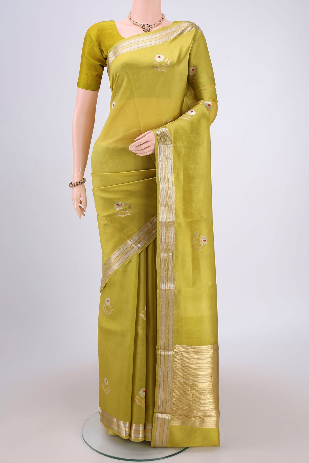 Light Green Banarasi Katan Silk Saree with Zari And Thread Butta on the body and Zari Border.  displayed on a mannequin