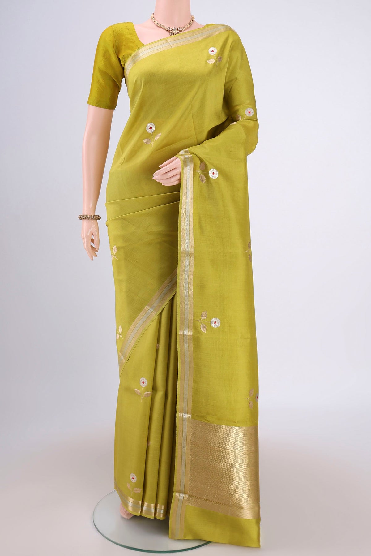 Light Green Banarasi Katan Silk Saree with Zari Butta on the body and Zari Border.  displayed on a mannequin
