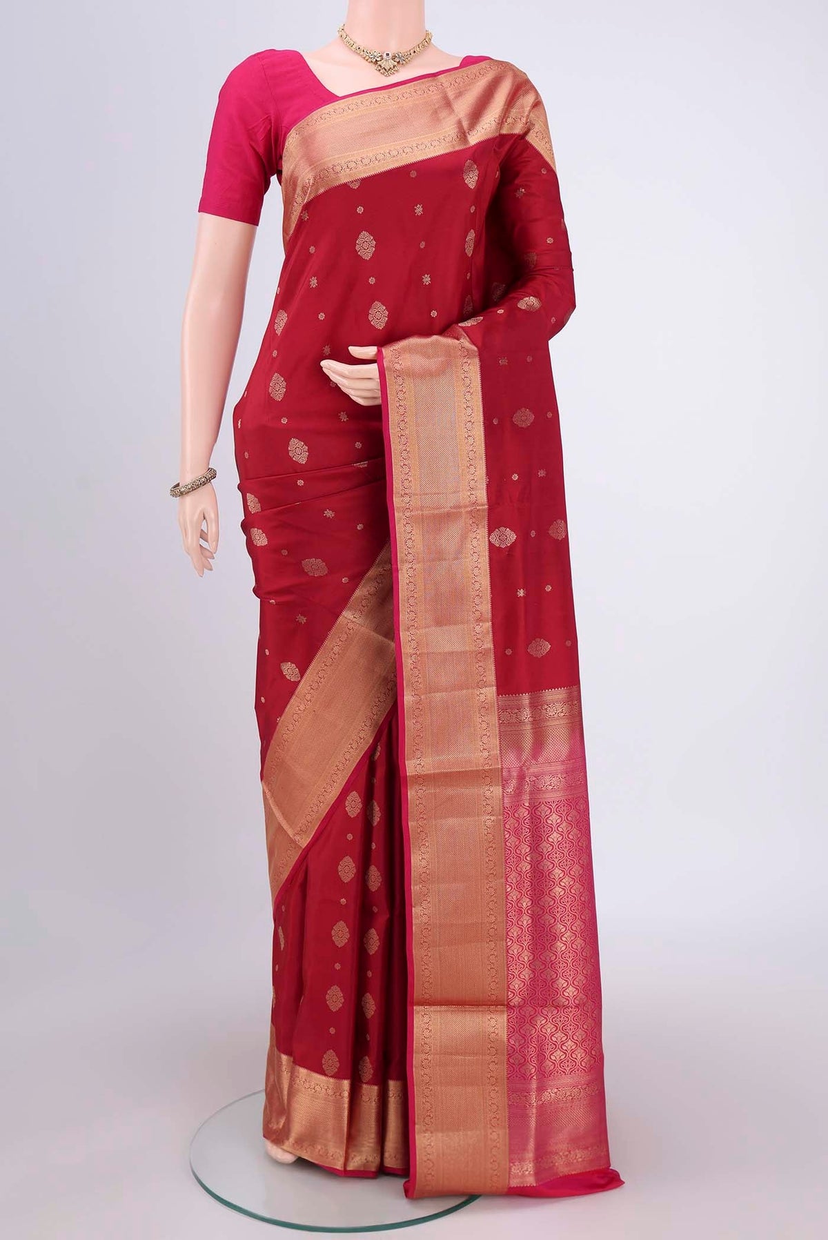 Maroon Soft Silk Saree with Zari Butta on the body and Zari Border.  displayed on a mannequin