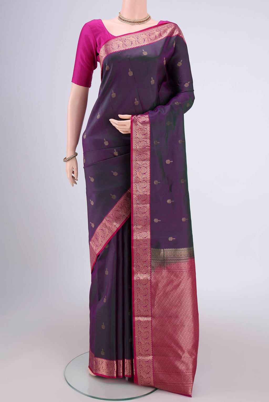 Purple with Green Color Kanjivaram Silk Saree with Zari Butta on the body and Zari Border.  displayed on a mannequin