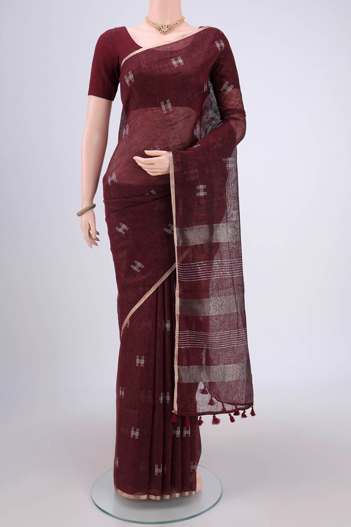 Maroon Blended Linen Saree with Thread Butta on the body and Zari Border.  displayed on a mannequin