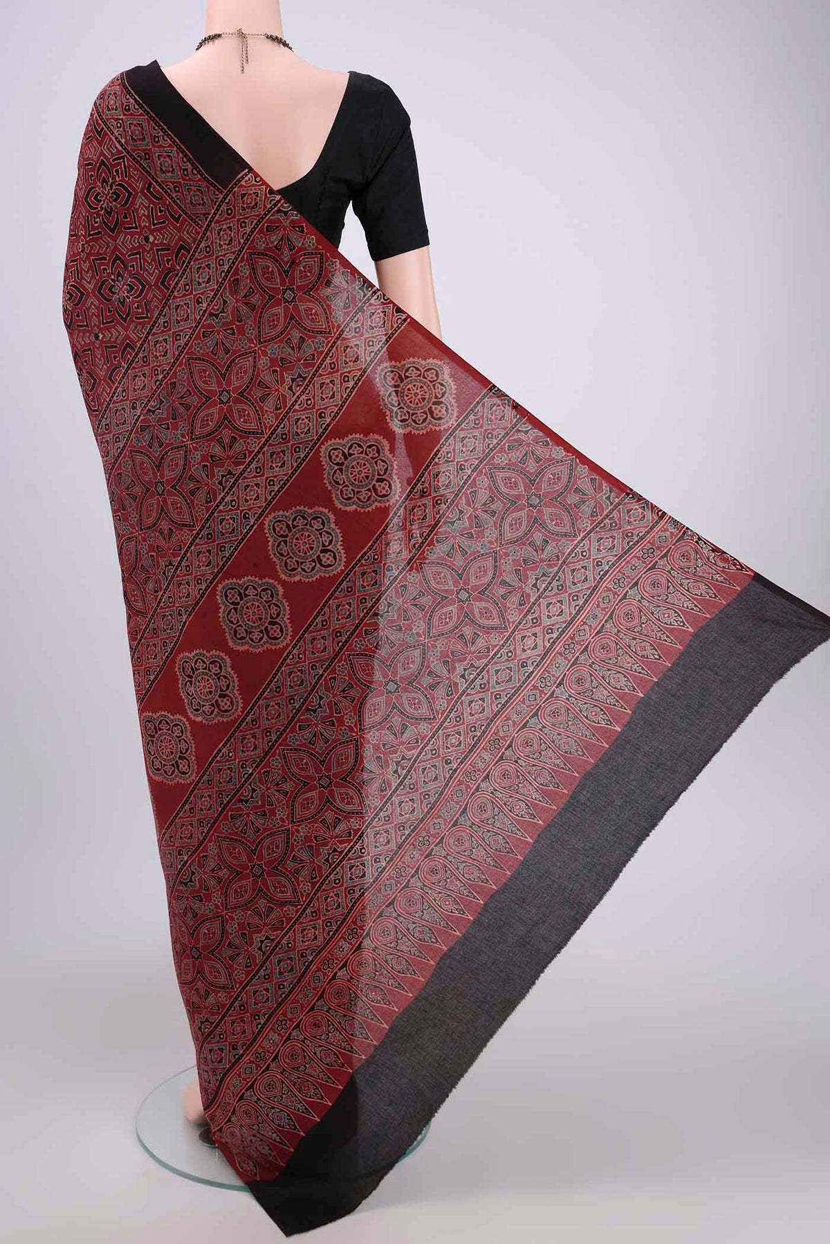 Flat view of Maroon Maheshwari Silk Cotton Saree with Ajrakh Print on the body and Plain Border. 