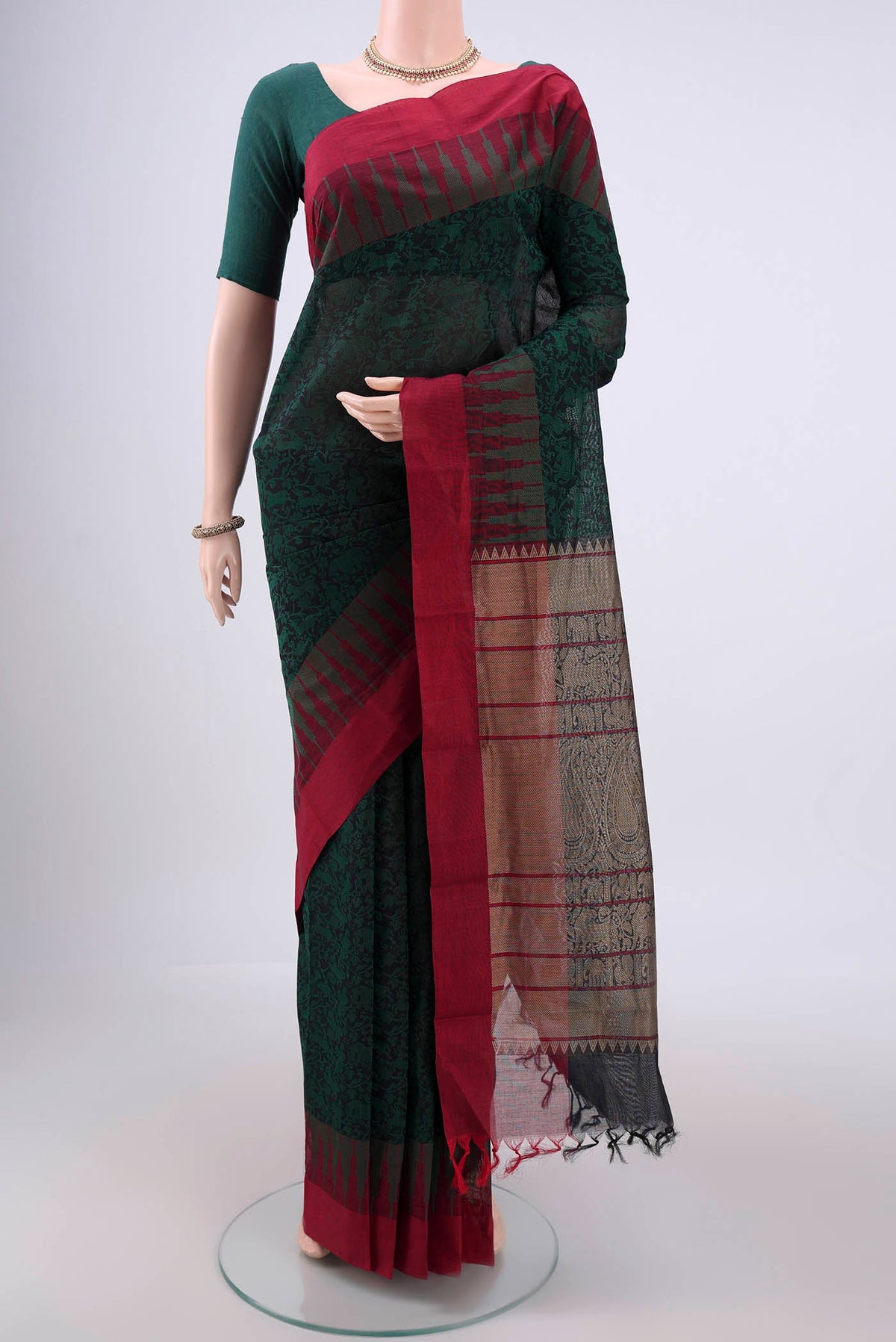 Bottle Green Kanchi Cotton Saree with Jacquard design on the body and Thread Border.  displayed on a mannequin
