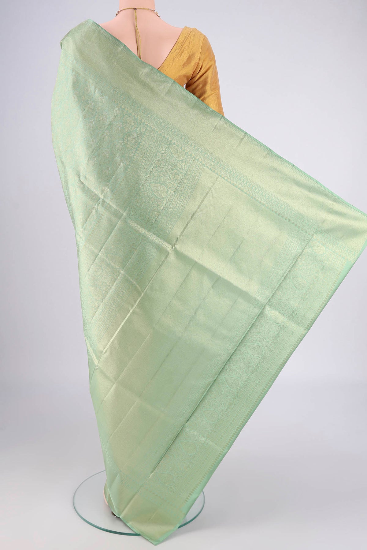 Flat view of Mint Green Soft Silk Saree with Zari Butta on the body and Zari Border. 