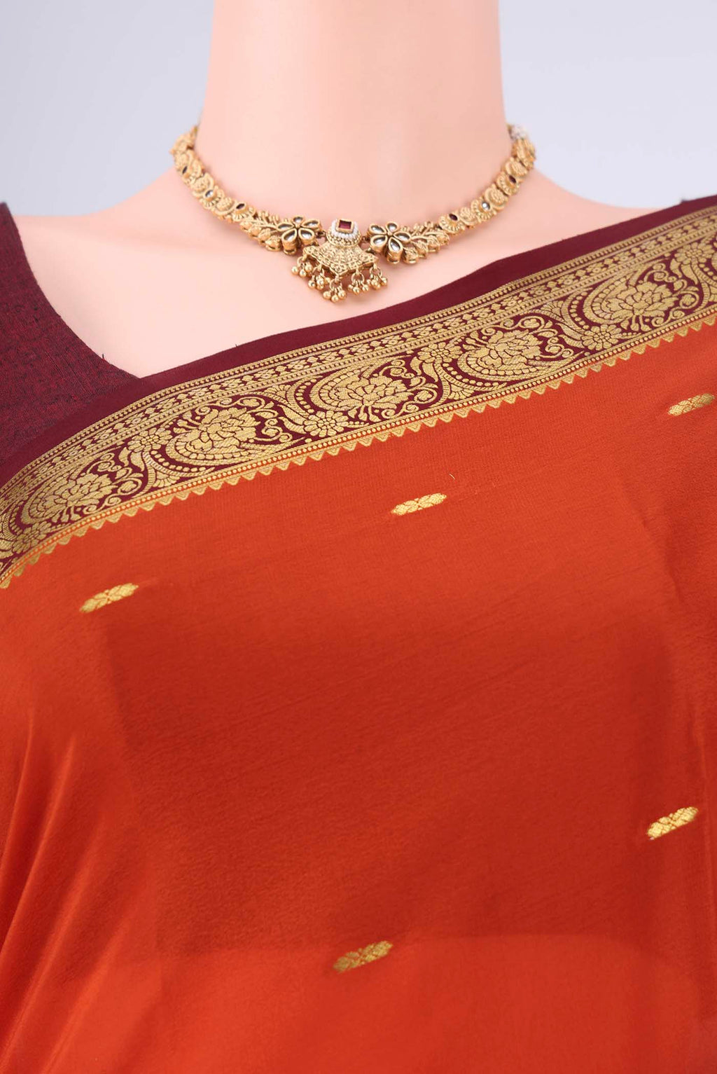 Rust Mysore Georgette Saree with Zari Butta on the body and Zari Border.  displayed on a mannequin