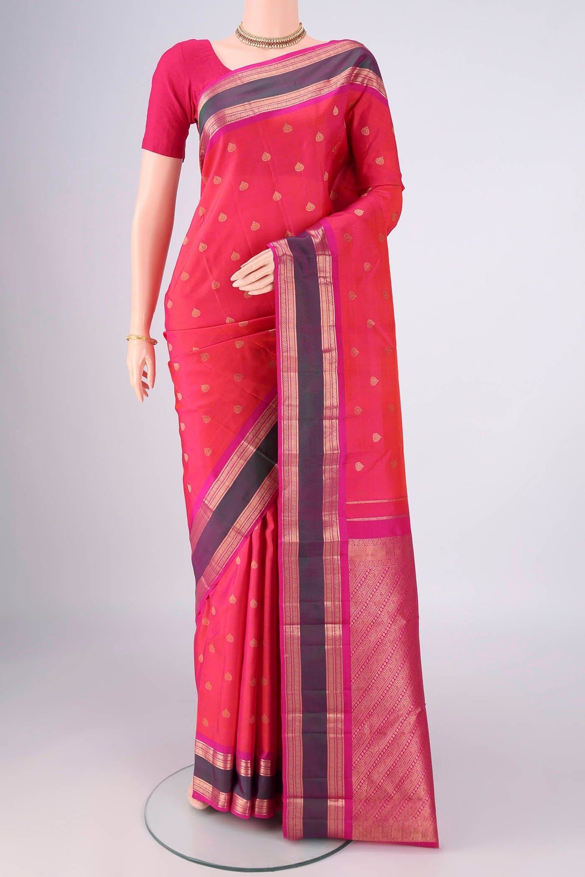 Coral Dual Tone Kanchipuram Silk Saree with Zari Butta on the body and Zari Border.  displayed on a mannequin