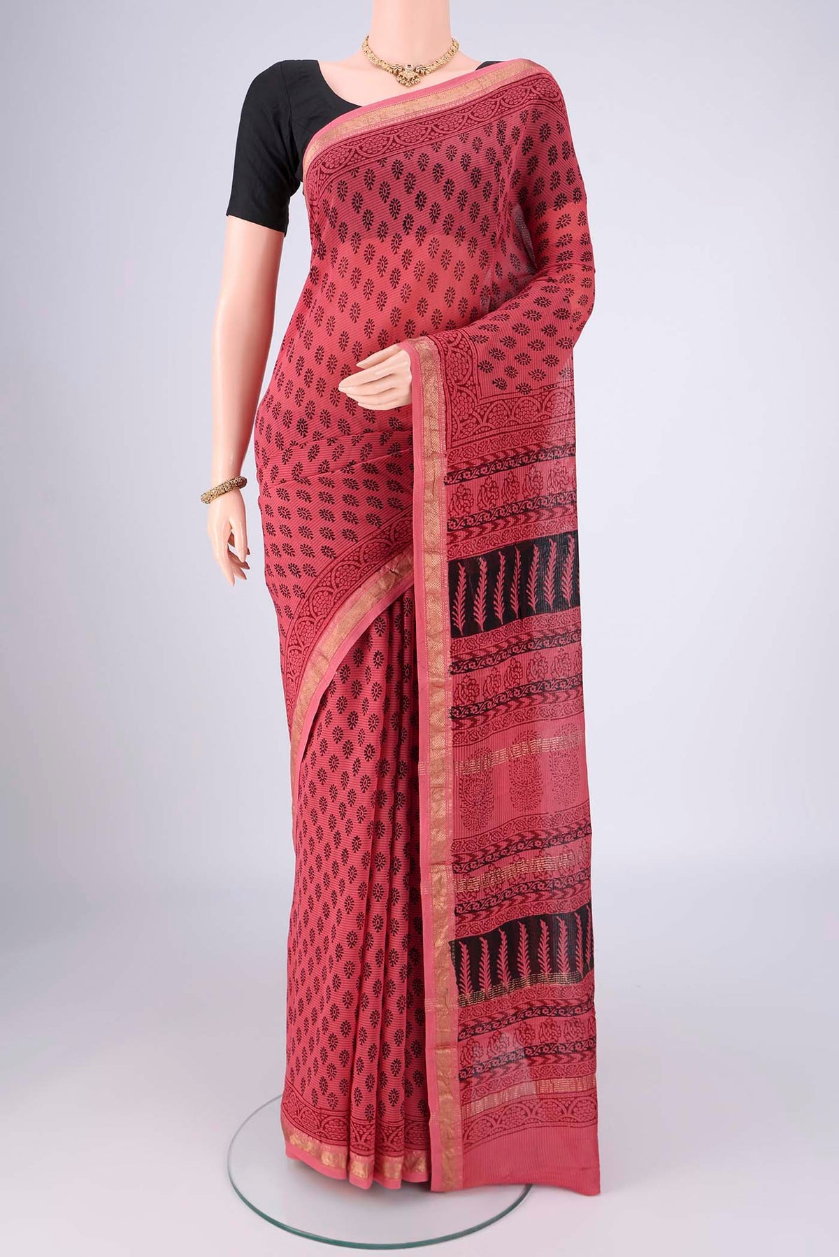 Coral Maheshwari Silk Cotton Saree with Printed design on the body and Zari Border.  displayed on a mannequin