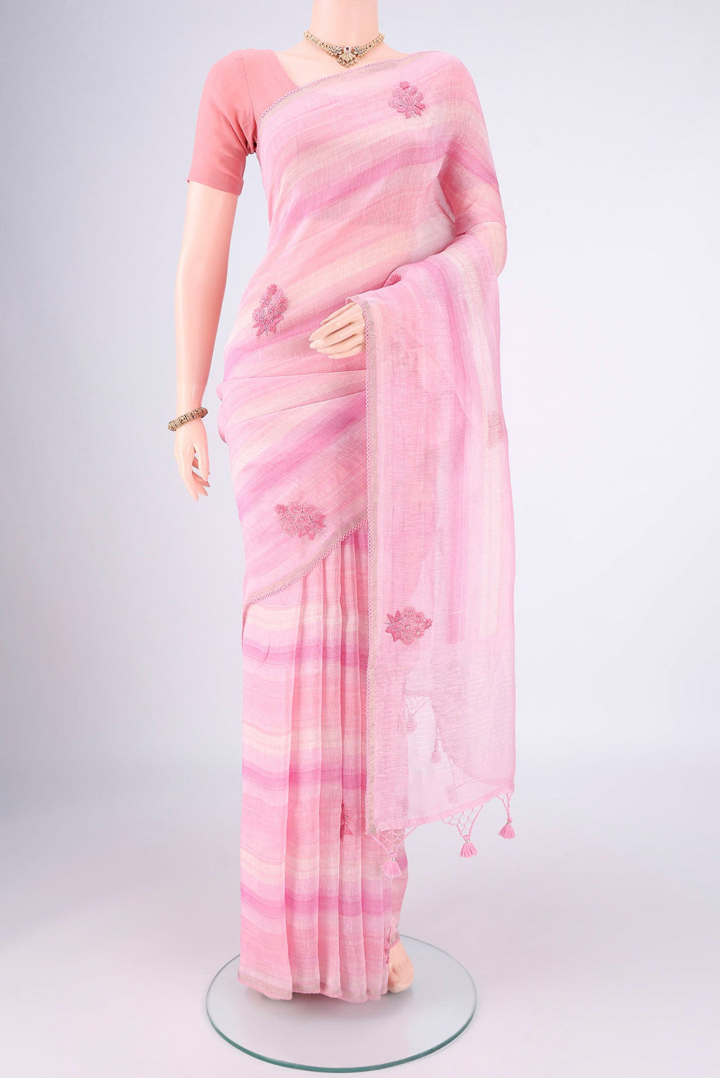 Pink Linen Saree with Embroidery on the body and Lace Border.  displayed on a mannequin