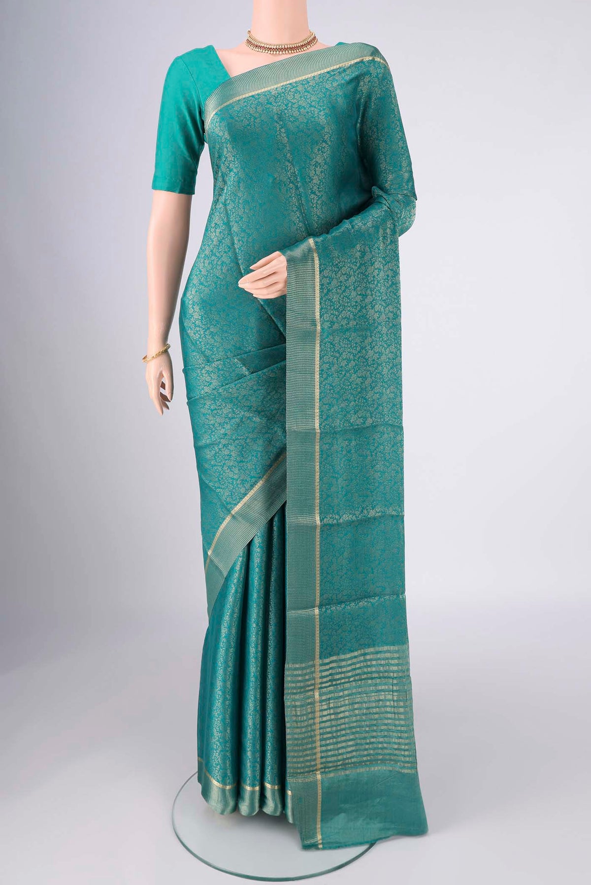 Turquoise Mysore Crepe Saree with Zari Butta on the body and Zari Border.  displayed on a mannequin