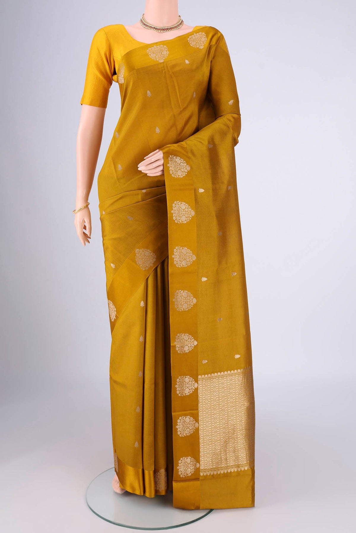 Mehandi Green Banarasi Katan Silk Saree with Zari Butta on the body and Satin Border.  displayed on a mannequin