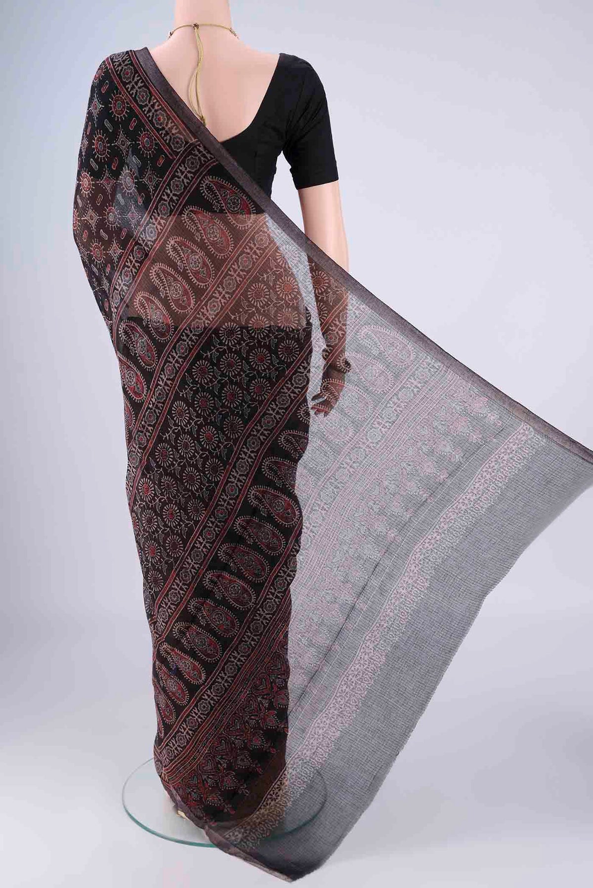 Flat view of Black Kota Cotton Saree with Ajrakh Print on the body and Zari Border. 