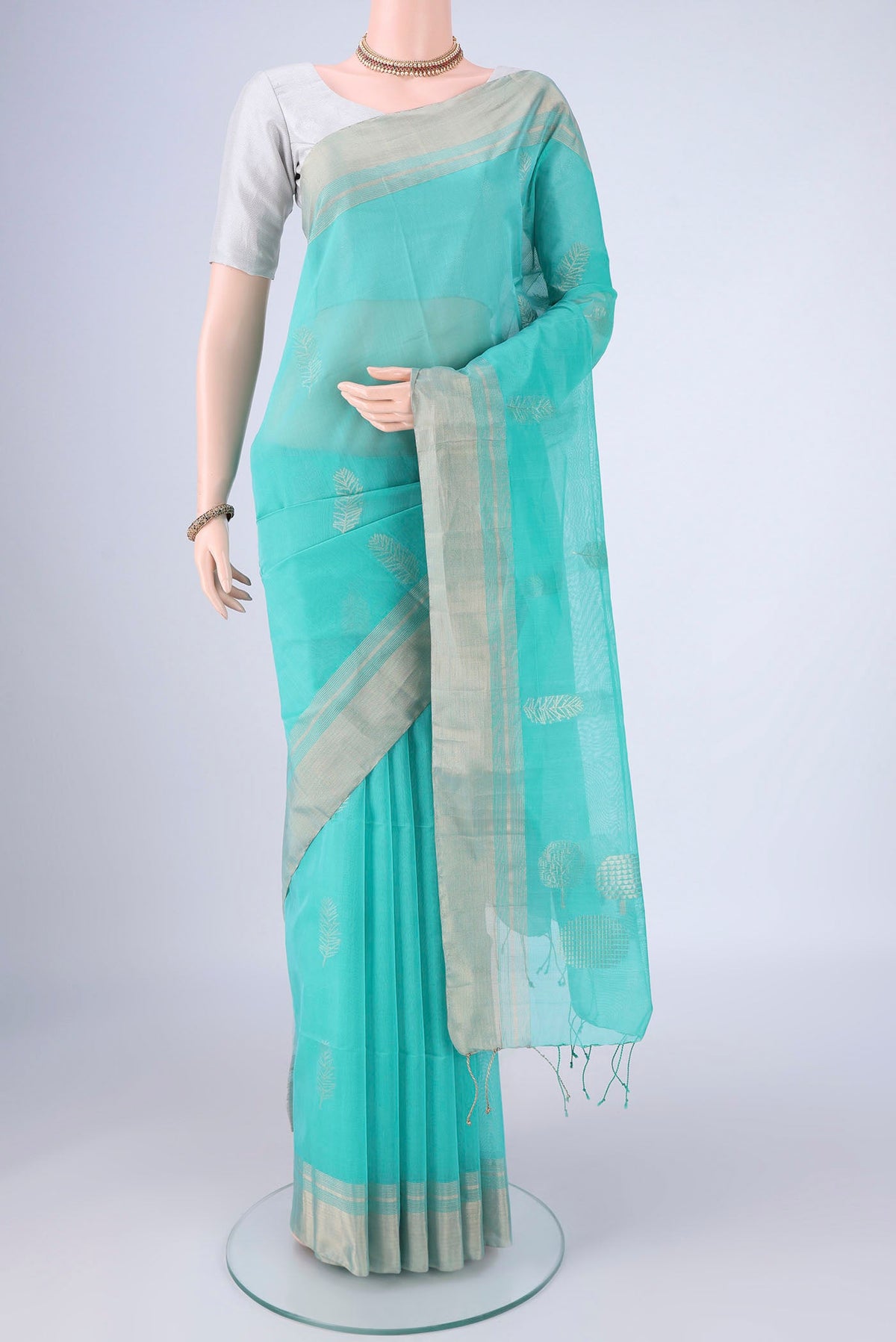 Light Blue Silk Cotton Saree with Zari Butta on the body and Zari Border.  displayed on a mannequin