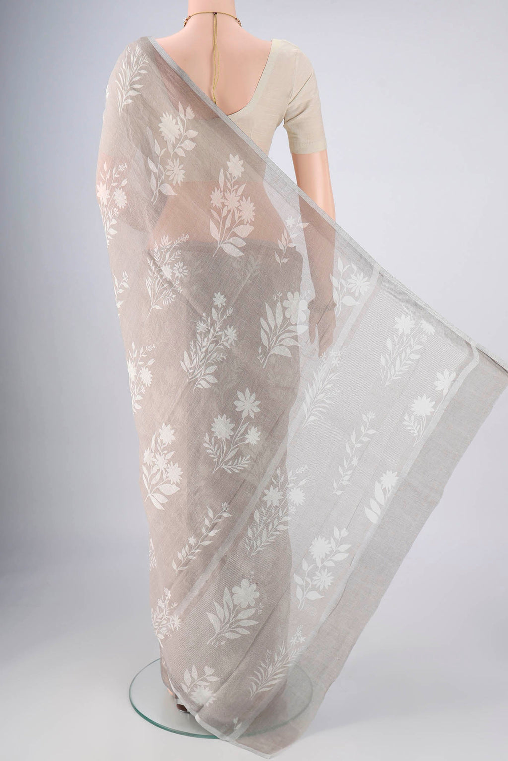 Flat view of Grey Linen Saree with Floral Print on the body and Zari Border. 